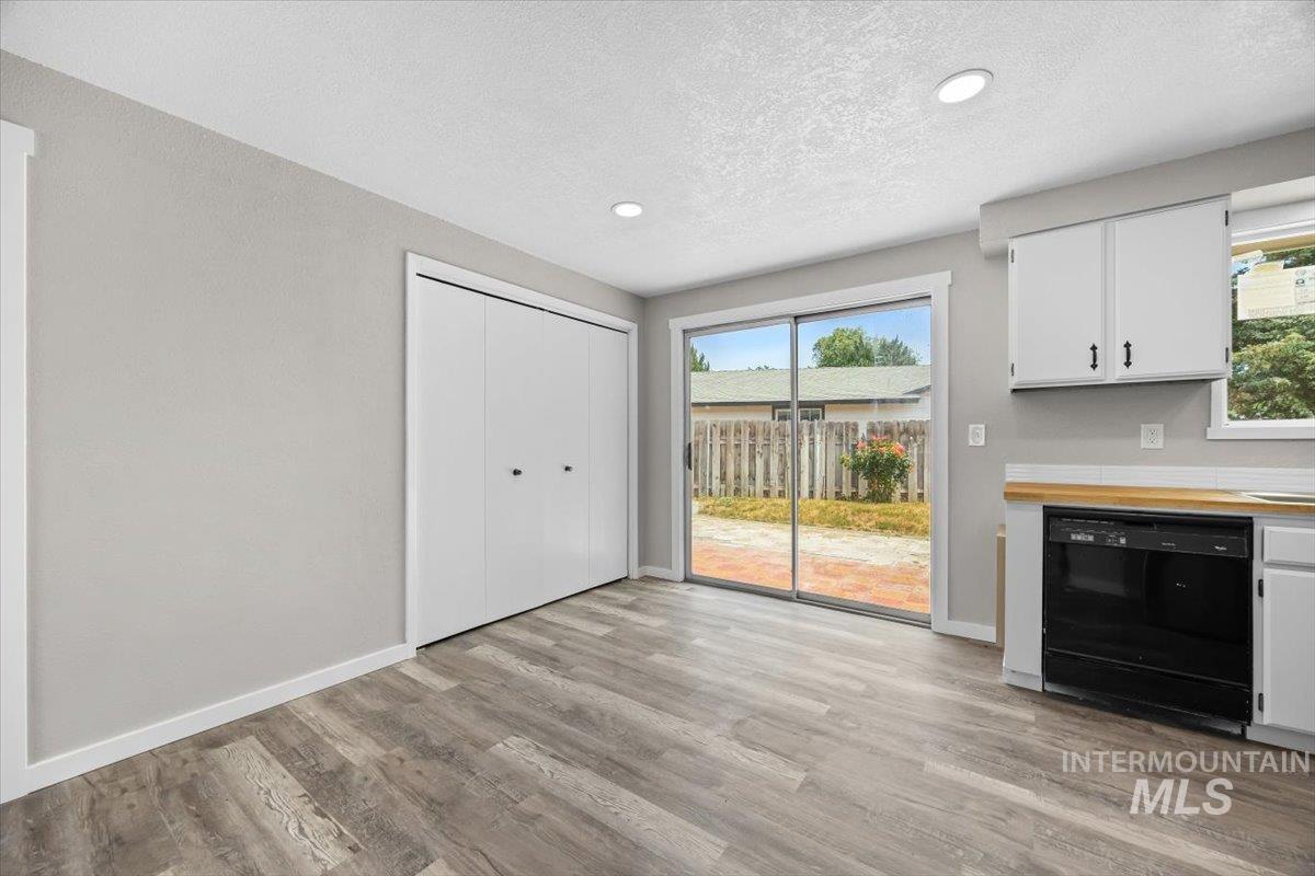 Unfurnished dining area with a textured ceiling, light wood finished floors, and recessed lighting