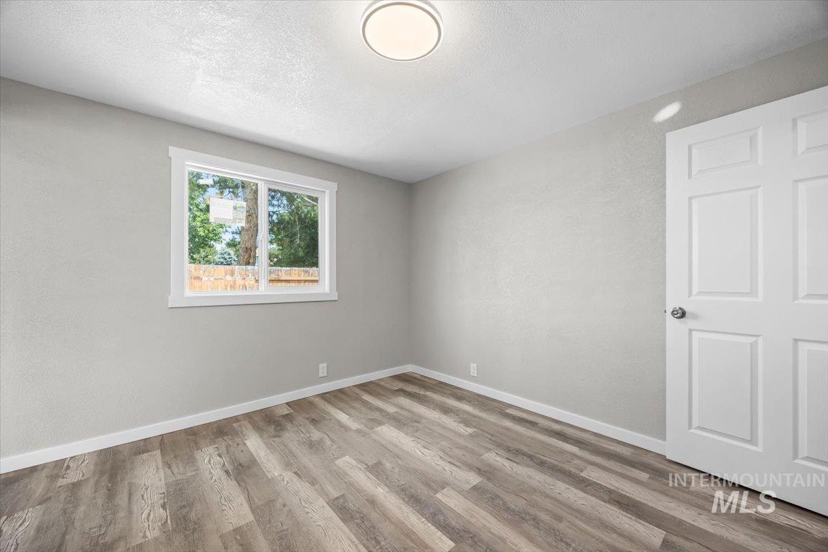 Unfurnished bedroom featuring wood finished floors and a textured ceiling