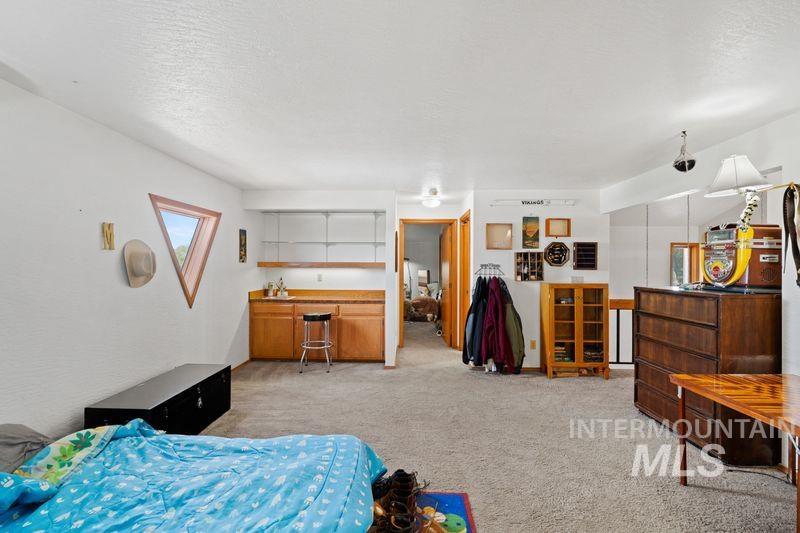 Bedroom with light colored carpet and a textured ceiling
