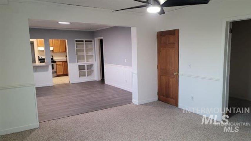 Empty room with carpet flooring and a ceiling fan
