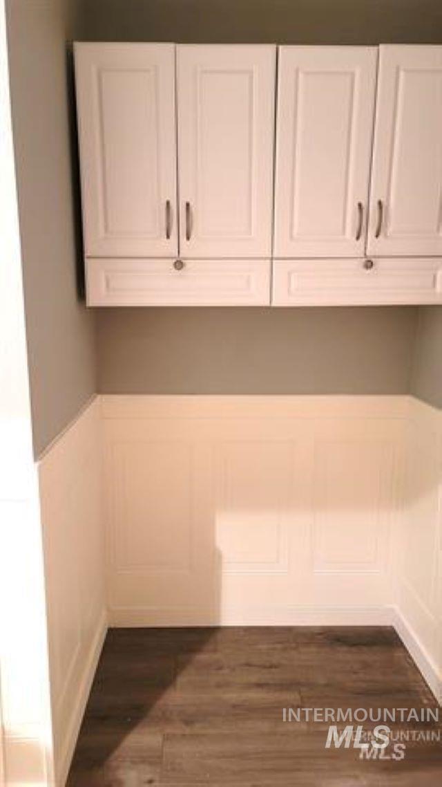 Washroom with wood finished floors and wainscoting