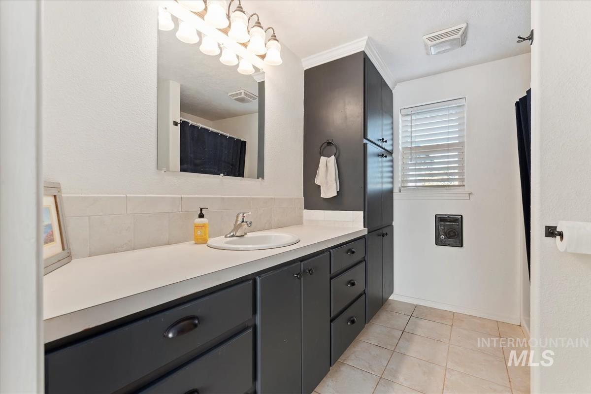 Bathroom with vanity, tile patterned floors, decorative backsplash, and curtained shower