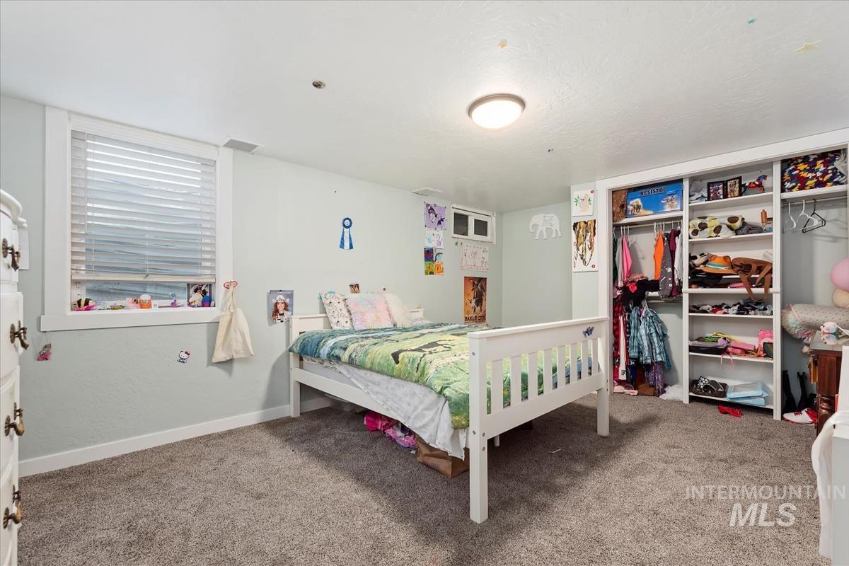 Carpeted bedroom featuring baseboards and a closet