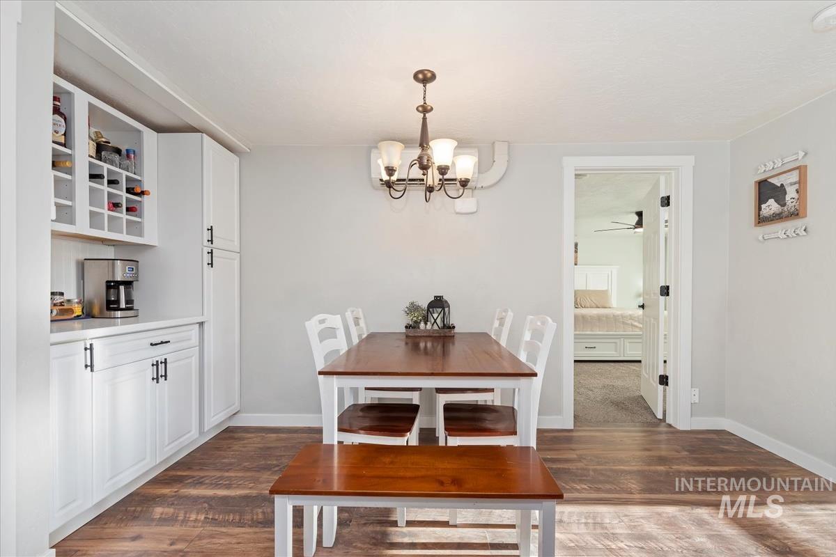 Dining space with dark wood-style flooring and a chandelier