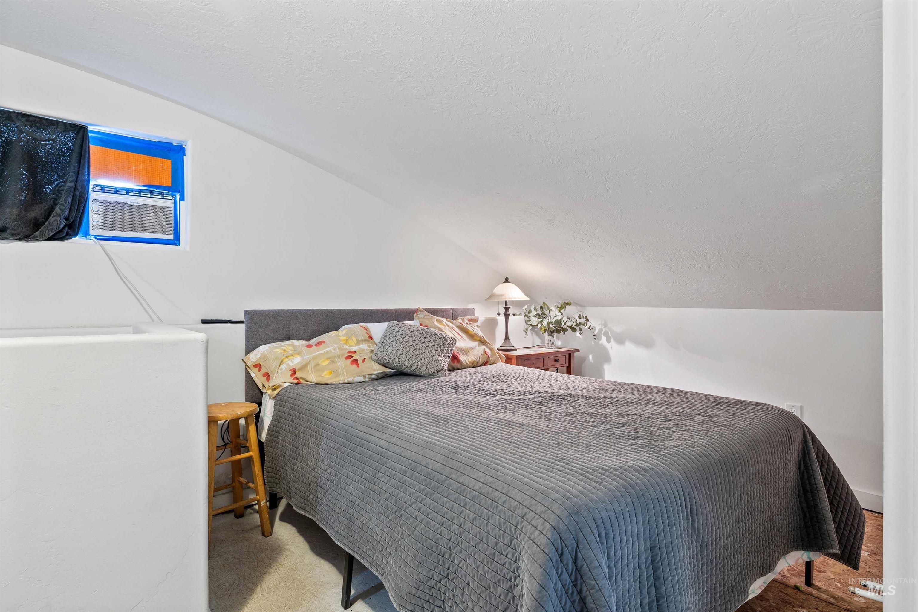 Bedroom featuring vaulted ceiling and a textured ceiling