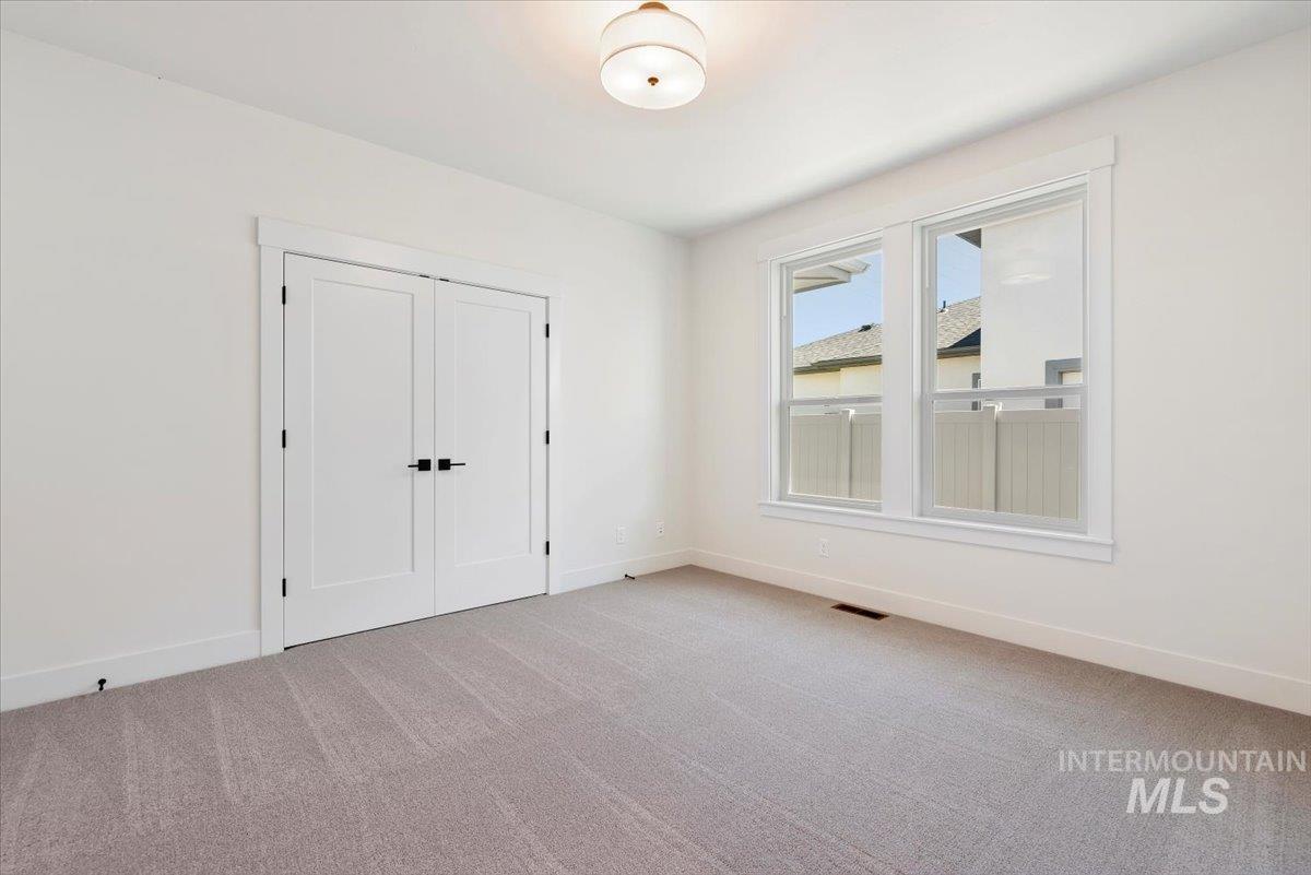 Unfurnished bedroom featuring light colored carpet and a closet