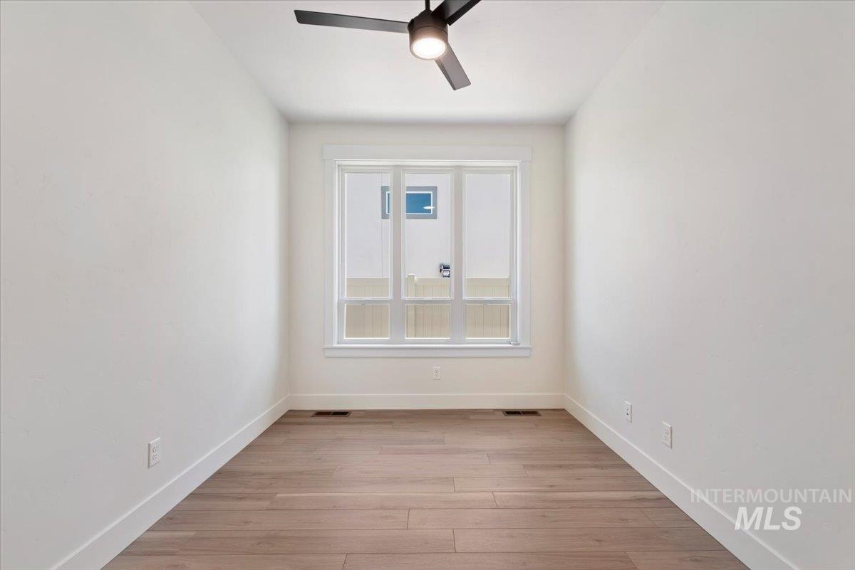 Spare room with light wood-type flooring and ceiling fan