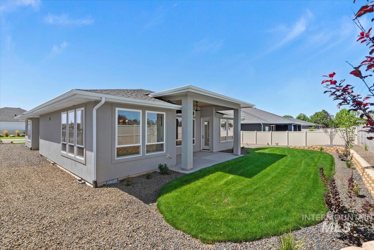 Rear view of property featuring a patio, stucco siding, and roof with shingles