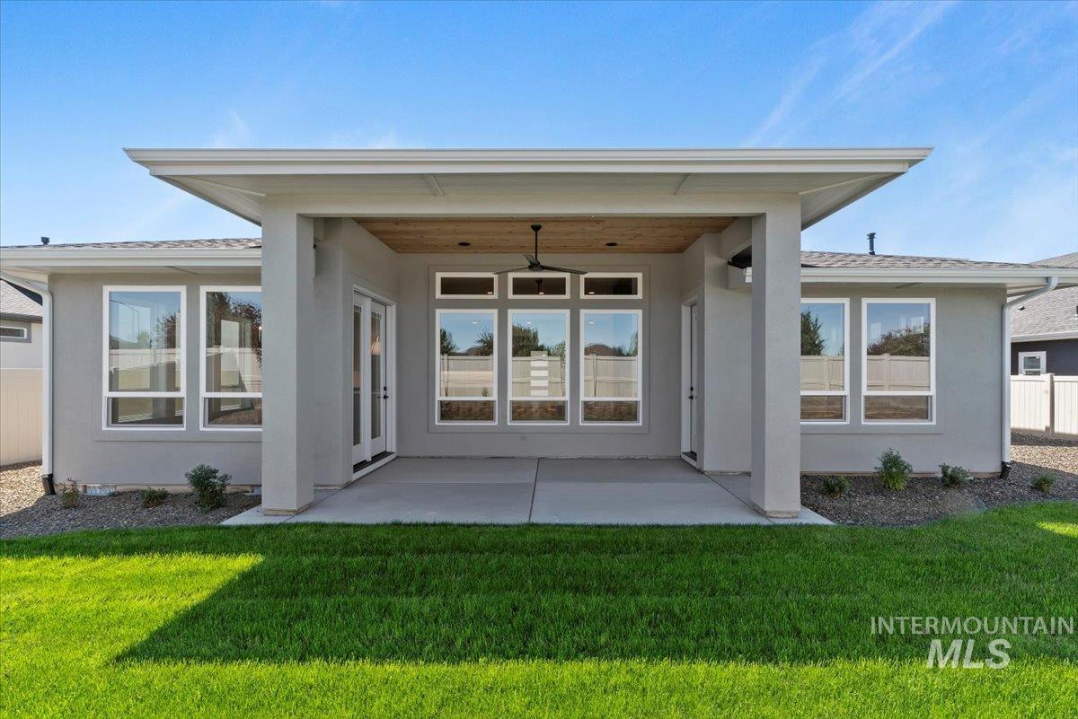 Back of house with a ceiling fan, stucco siding, a patio, and a shingled roof