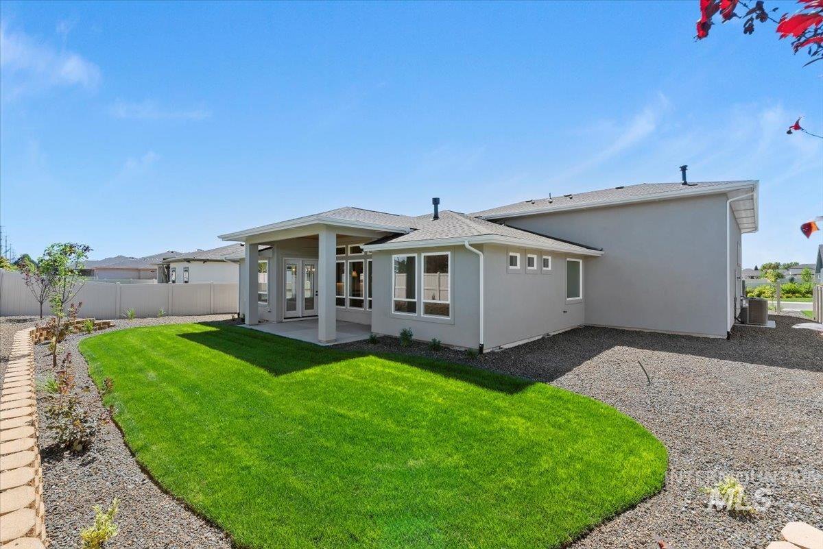 Rear view of property with a patio area, stucco siding, and roof with shingles
