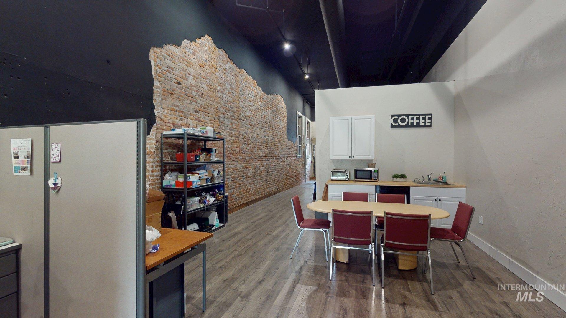 Break area with brick wall and wood finished floors