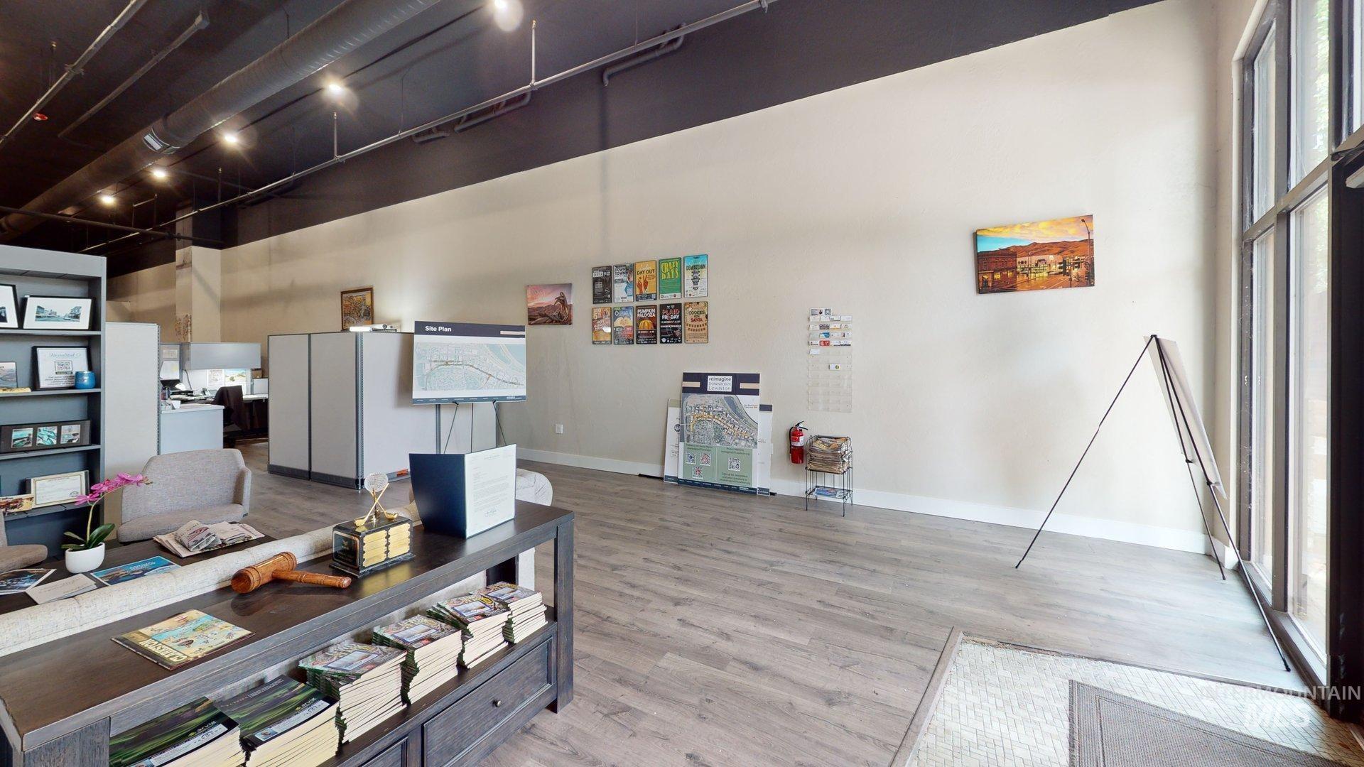 Office with a high ceiling, wood finished floors, and rail lighting