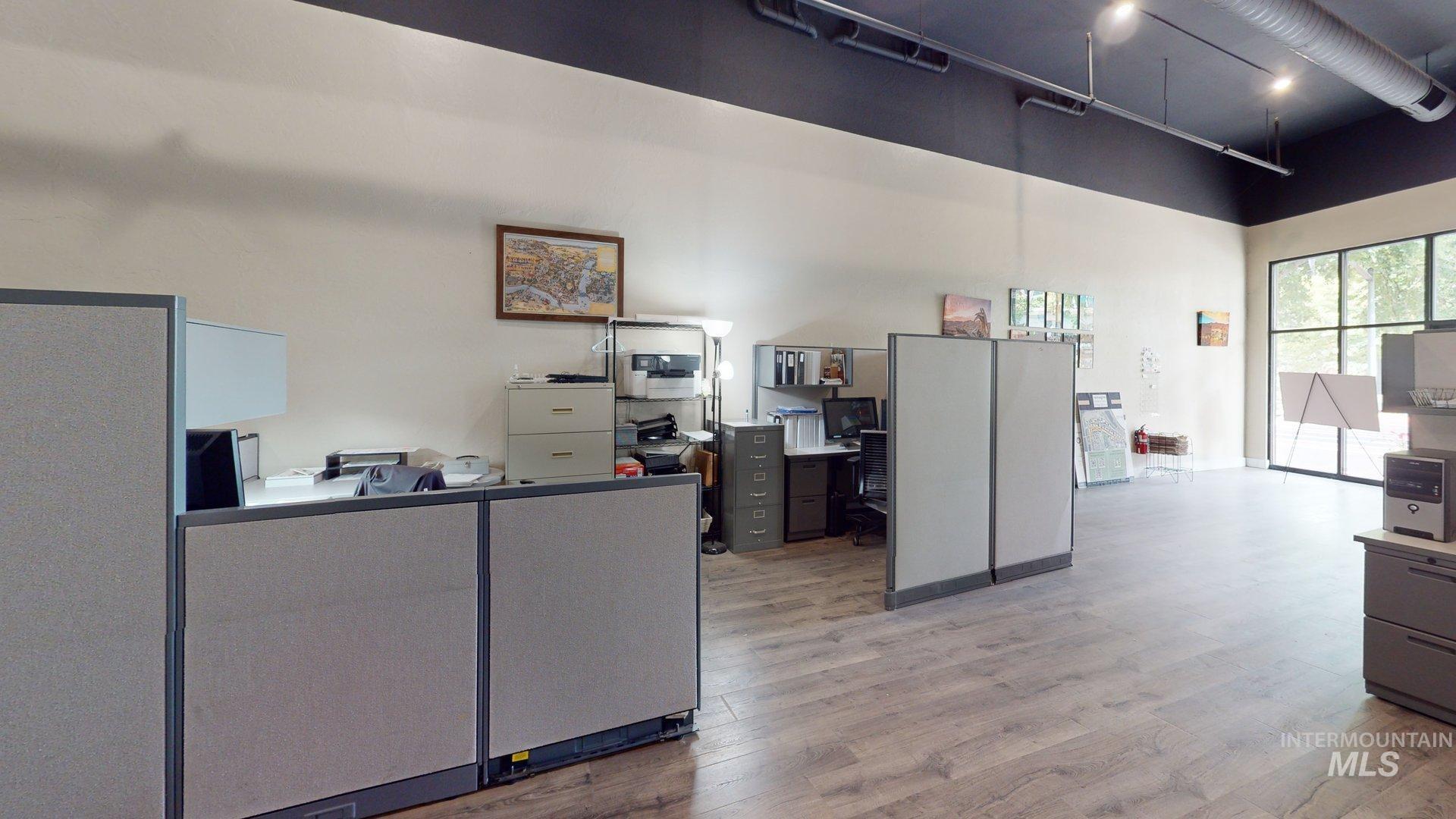 Office space featuring wood finished floors and a towering ceiling