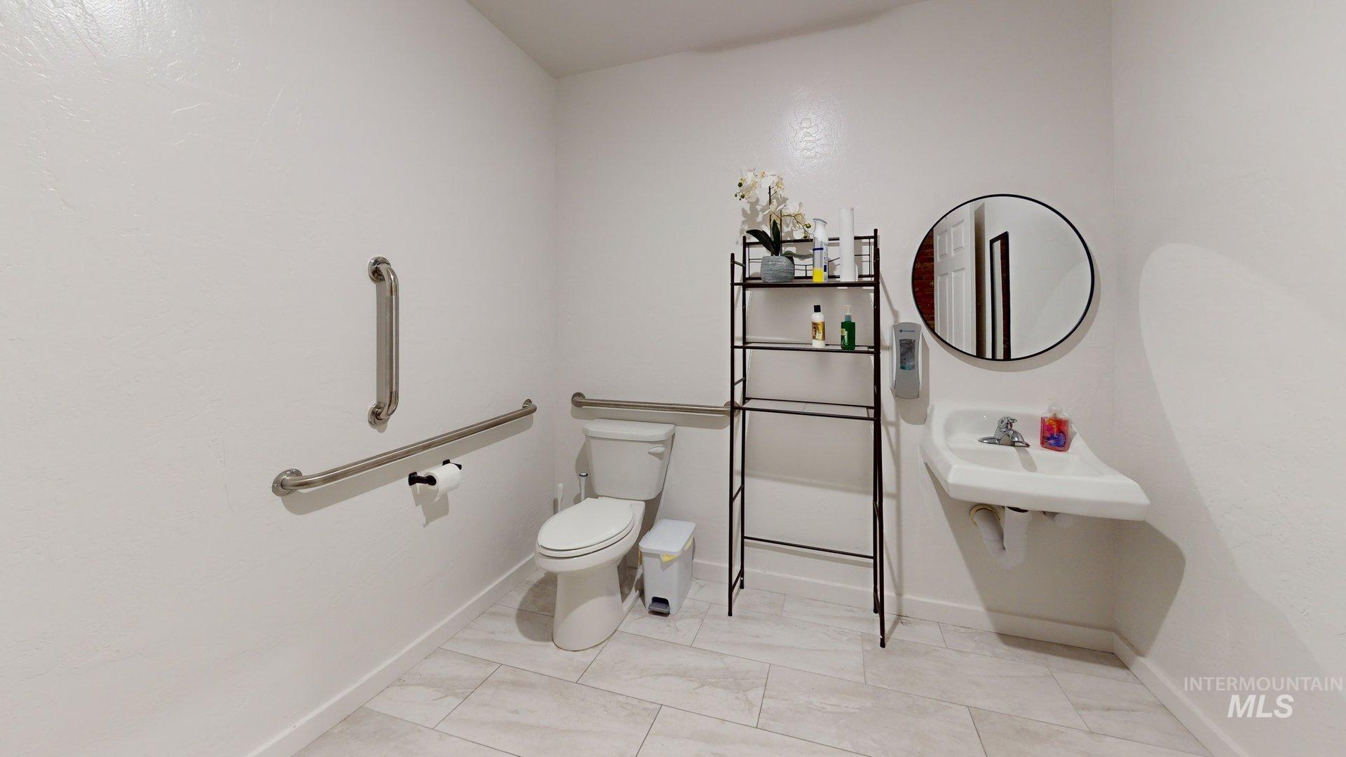 Bathroom featuring toilet and marble look tile flooring