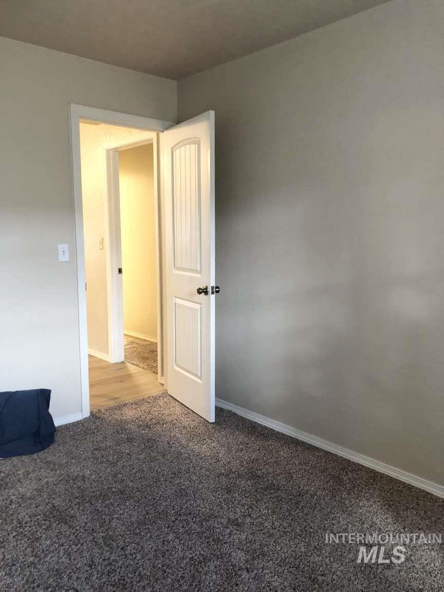Spare room with carpet and baseboards