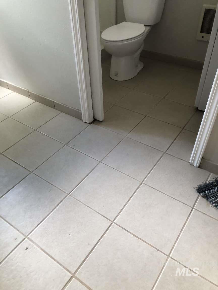 Bathroom featuring light tile patterned floors and heating unit
