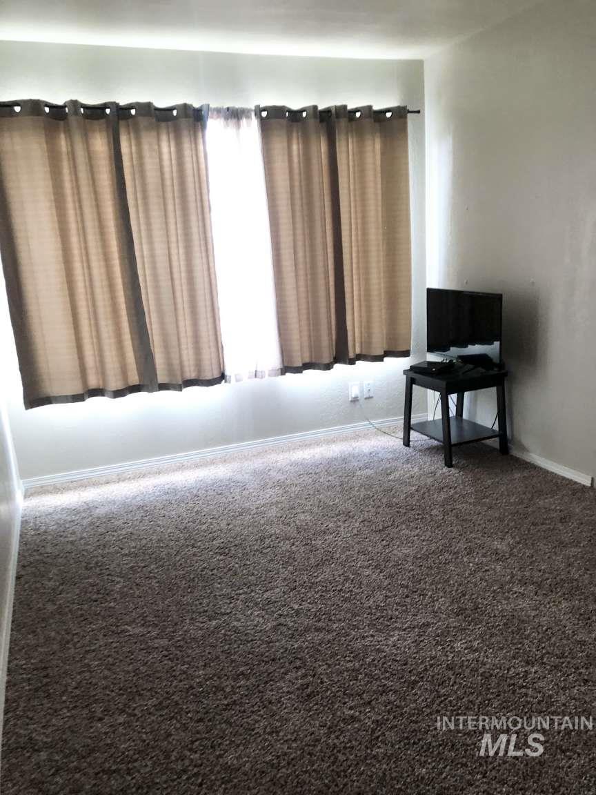 Sitting room featuring carpet flooring and baseboards