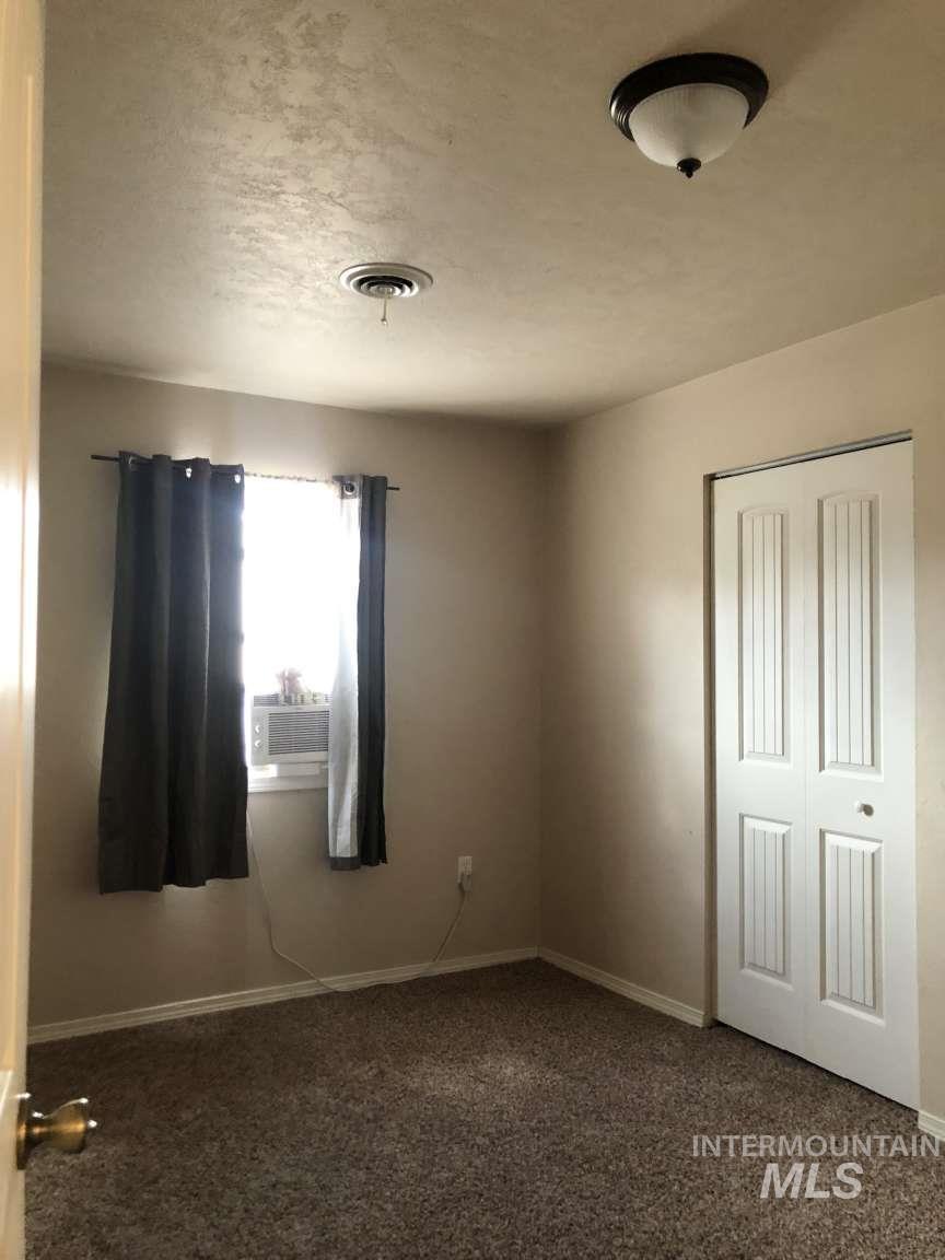 Unfurnished bedroom featuring carpet, a closet, and a textured ceiling