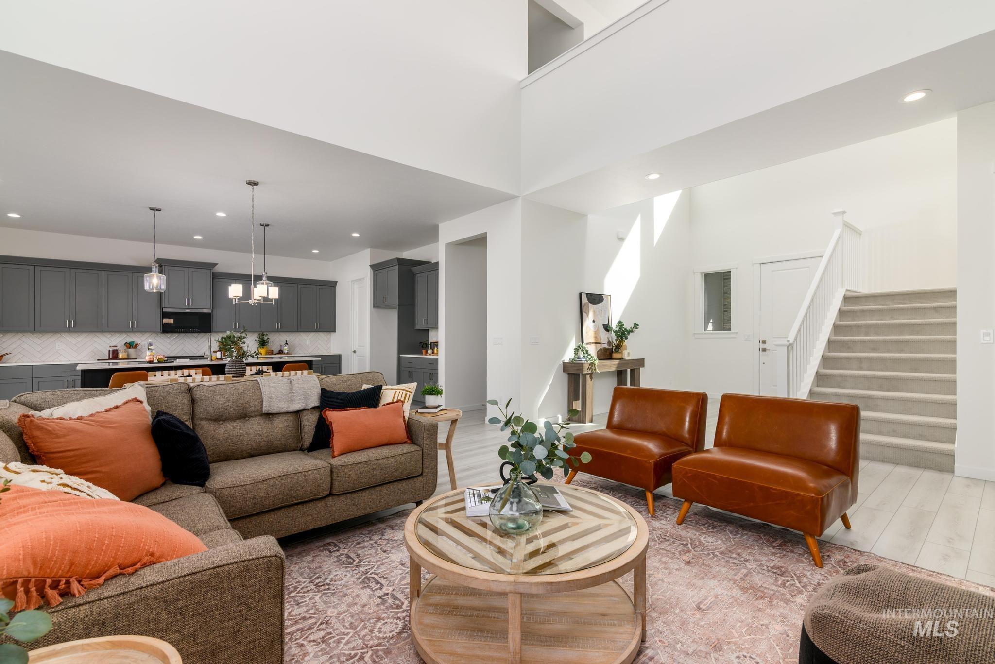 Living area with recessed lighting, stairway, a towering ceiling, wood finished floors, and a chandelier
