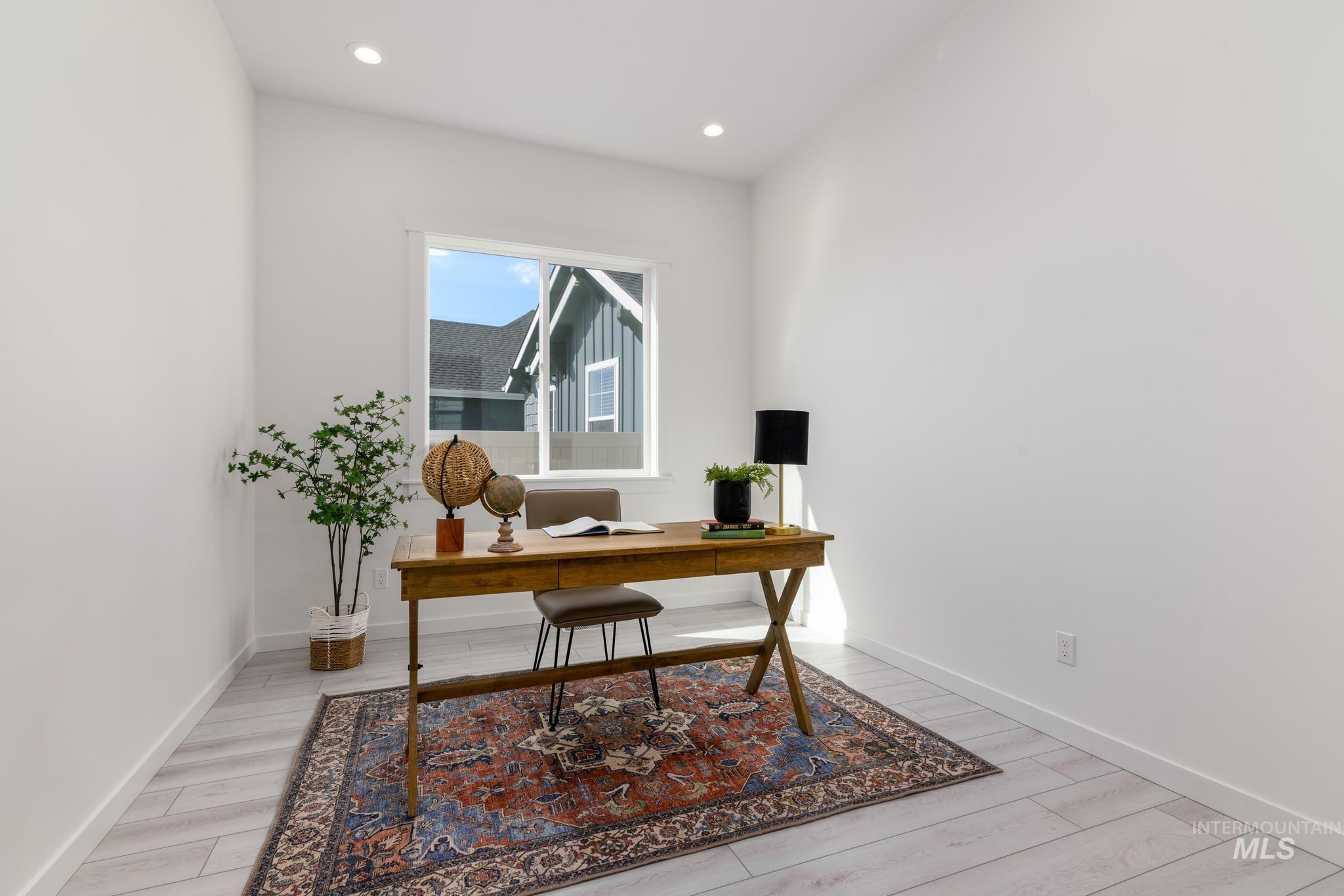 Office with recessed lighting and light wood-style flooring