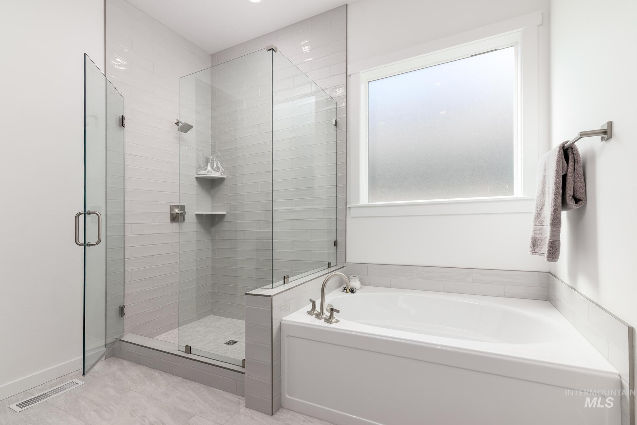 Full bath with a bath, a stall shower, and light tile patterned floors