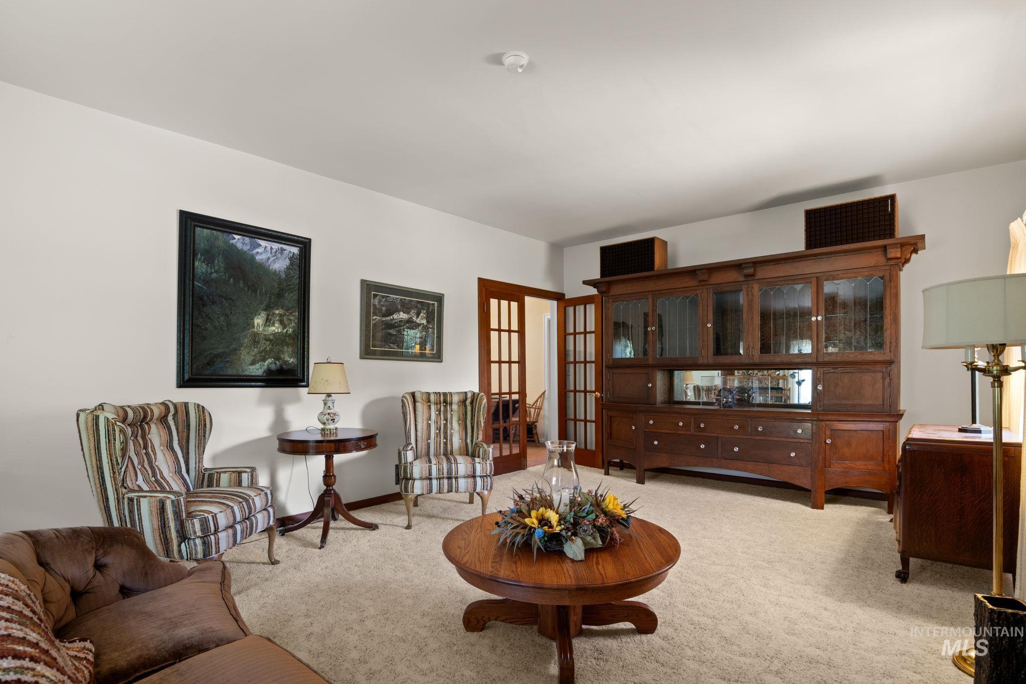 Living area featuring french doors and light carpet