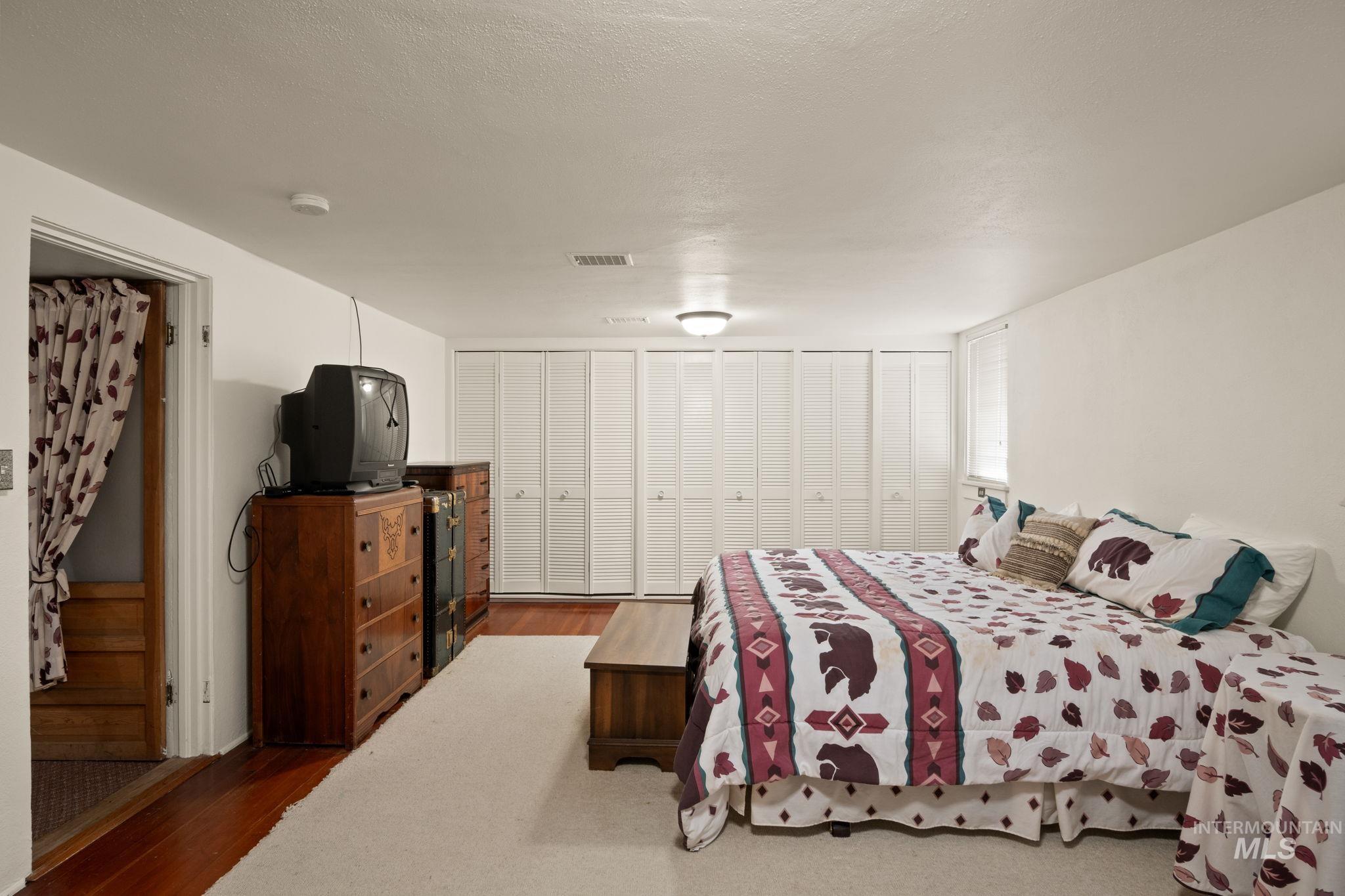 Bedroom featuring wood finished floors and a textured ceiling
