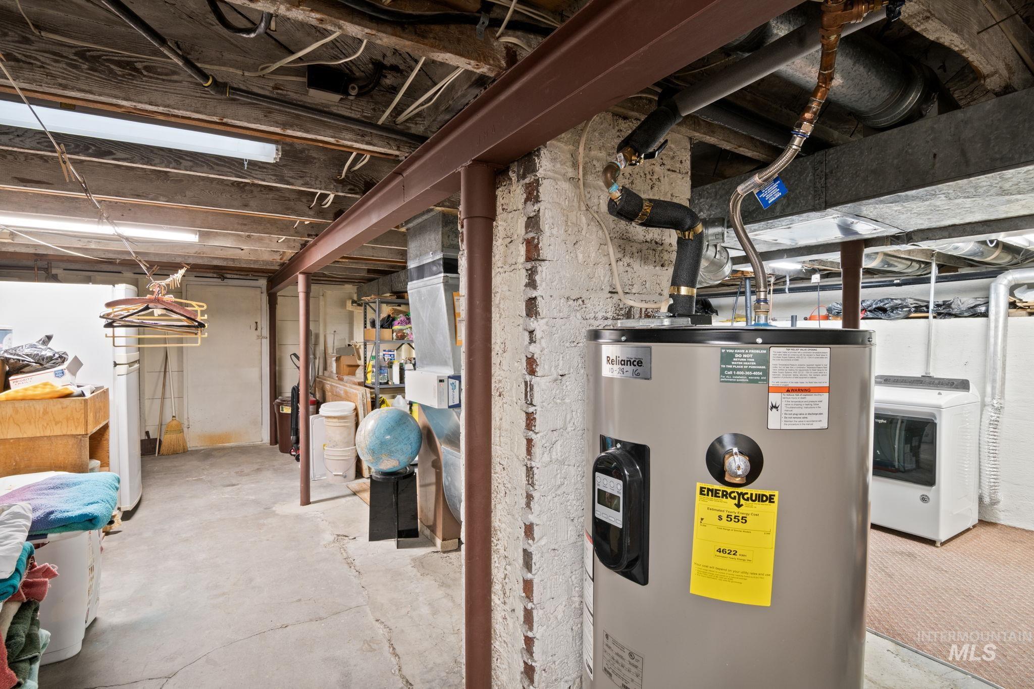Unfinished basement with water heater and washer / clothes dryer