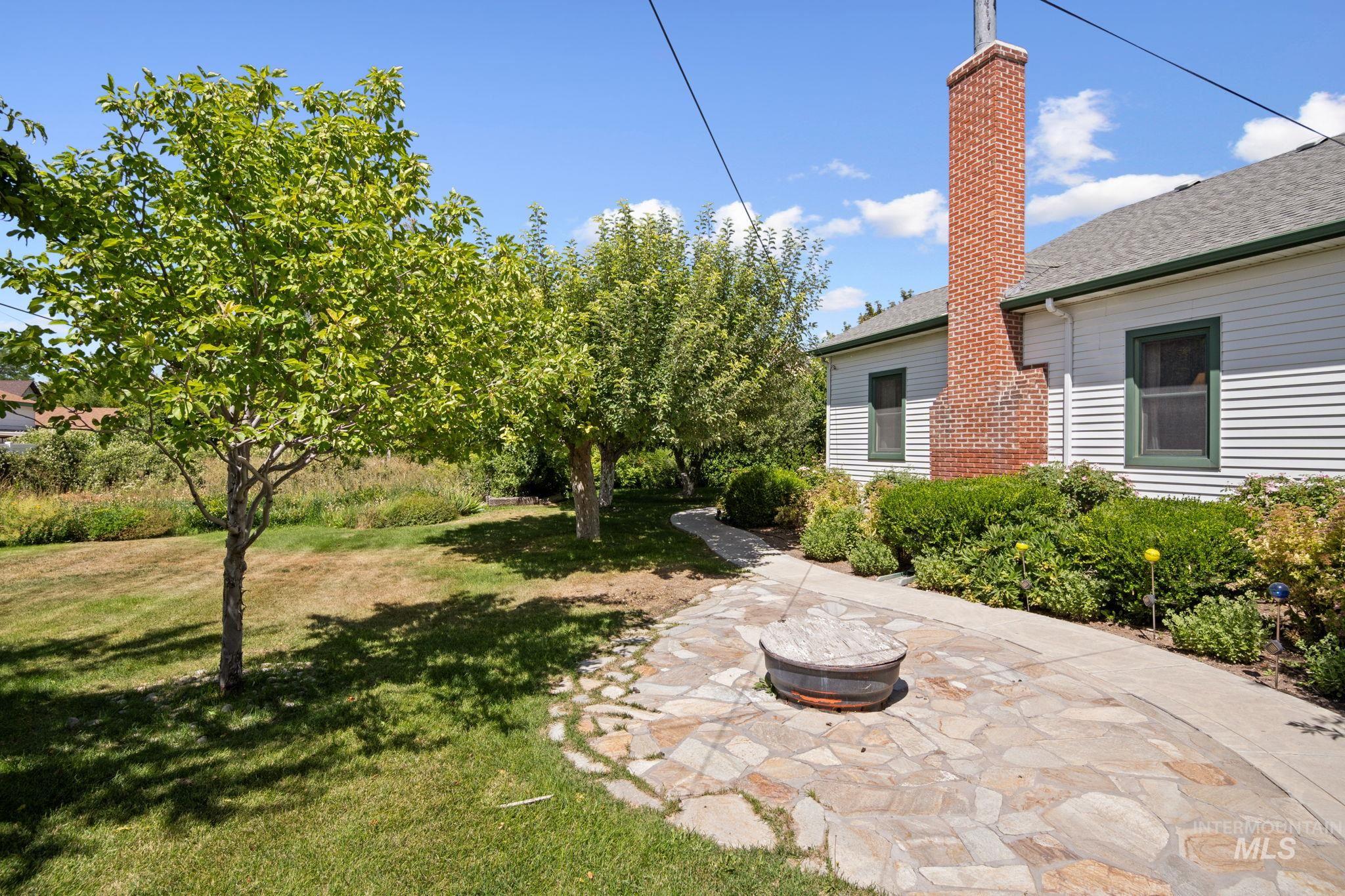 View of grassy yard with an outdoor fire pit
