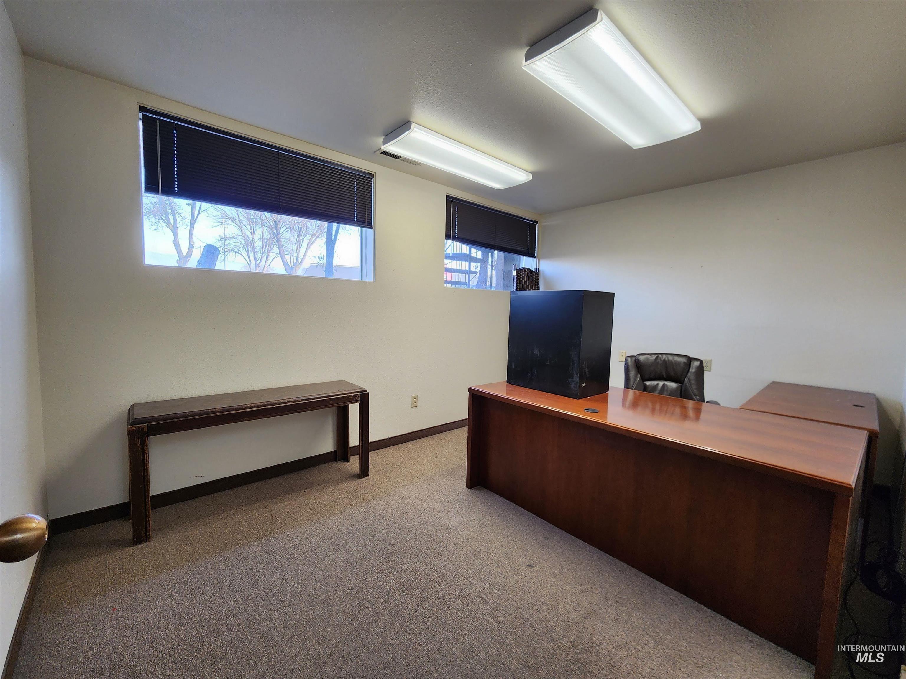 Carpeted home office with baseboards