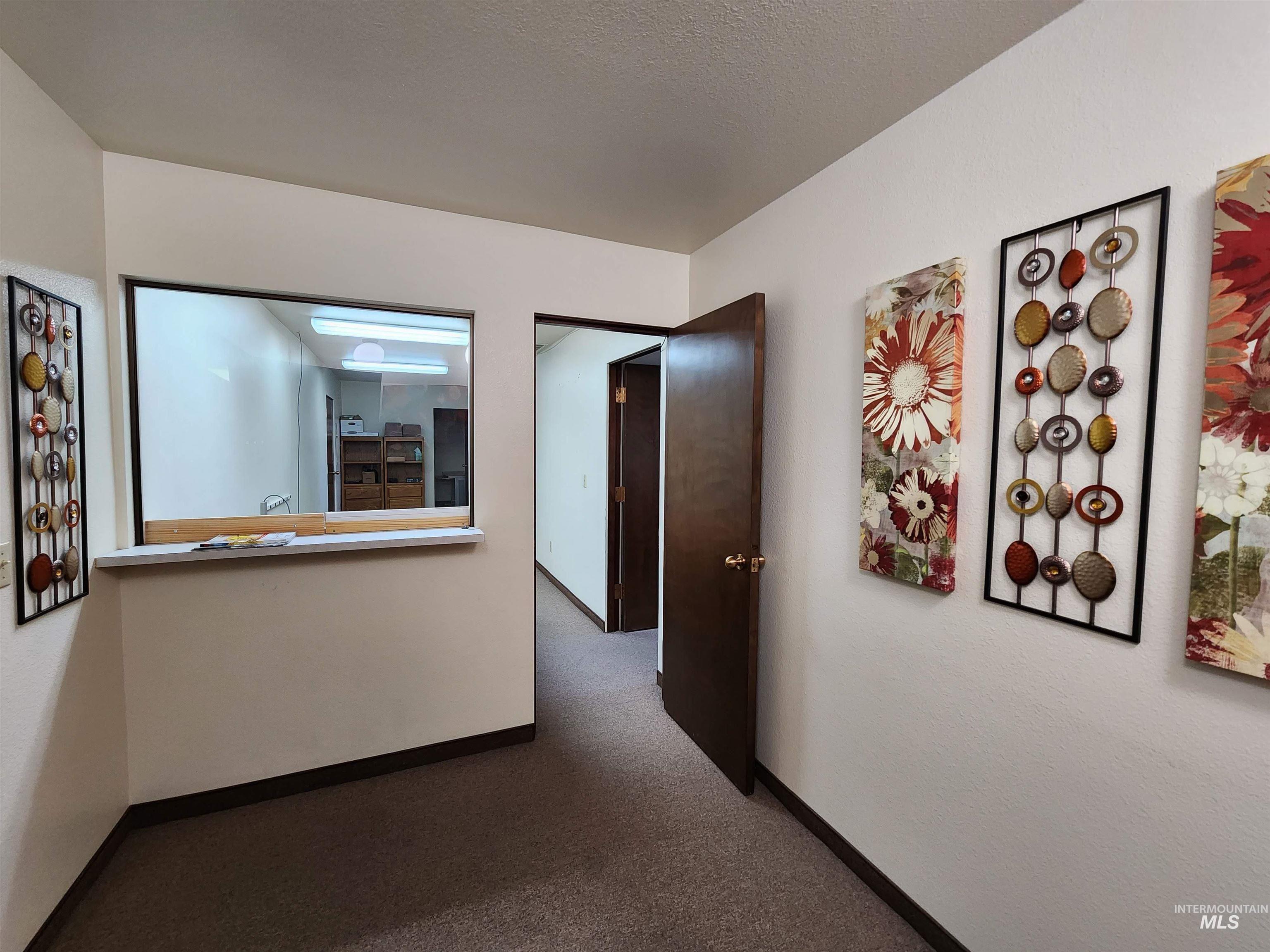 Hallway with carpet flooring and a textured ceiling