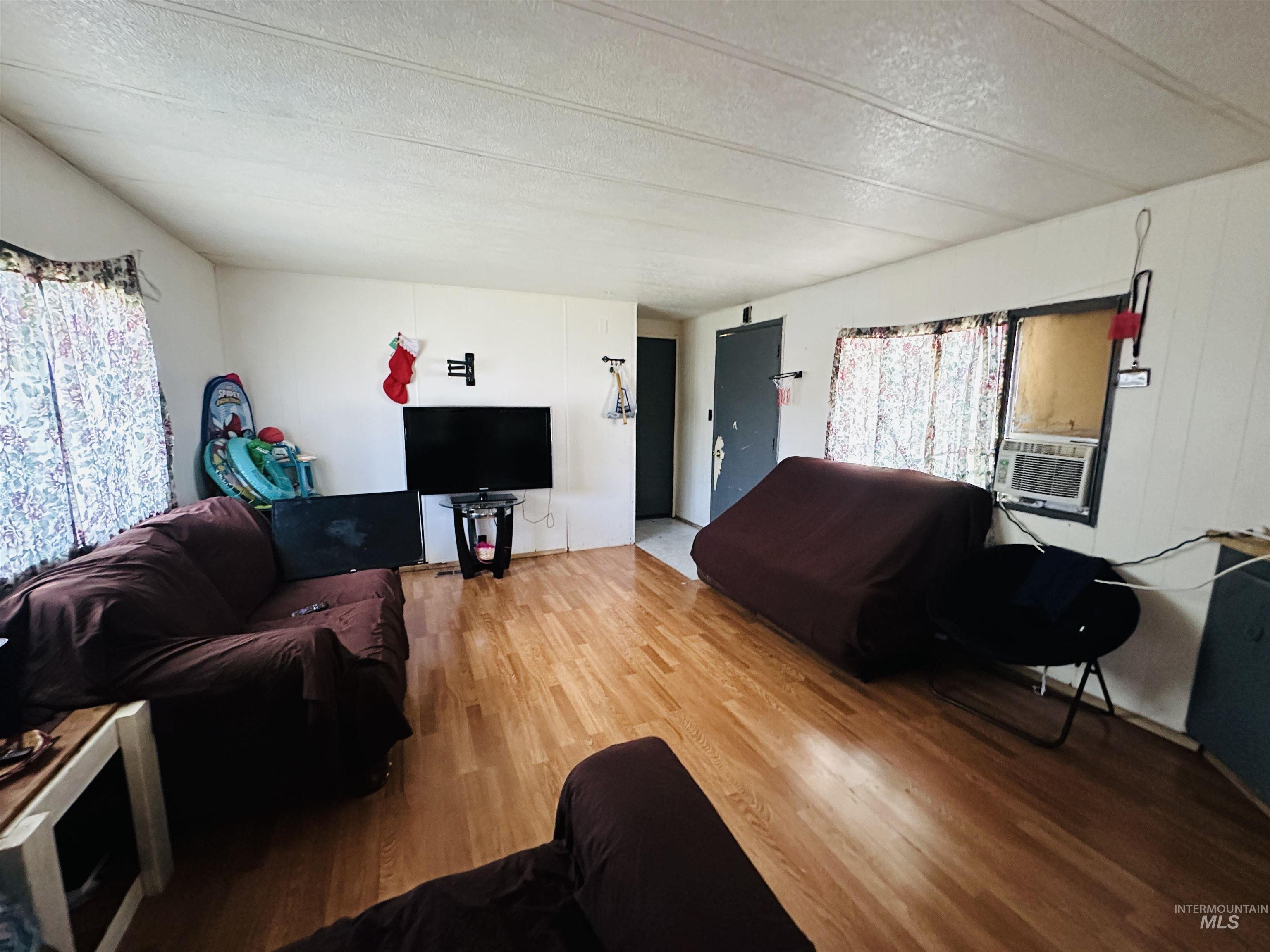 Living room featuring a textured ceiling and wood finished floors