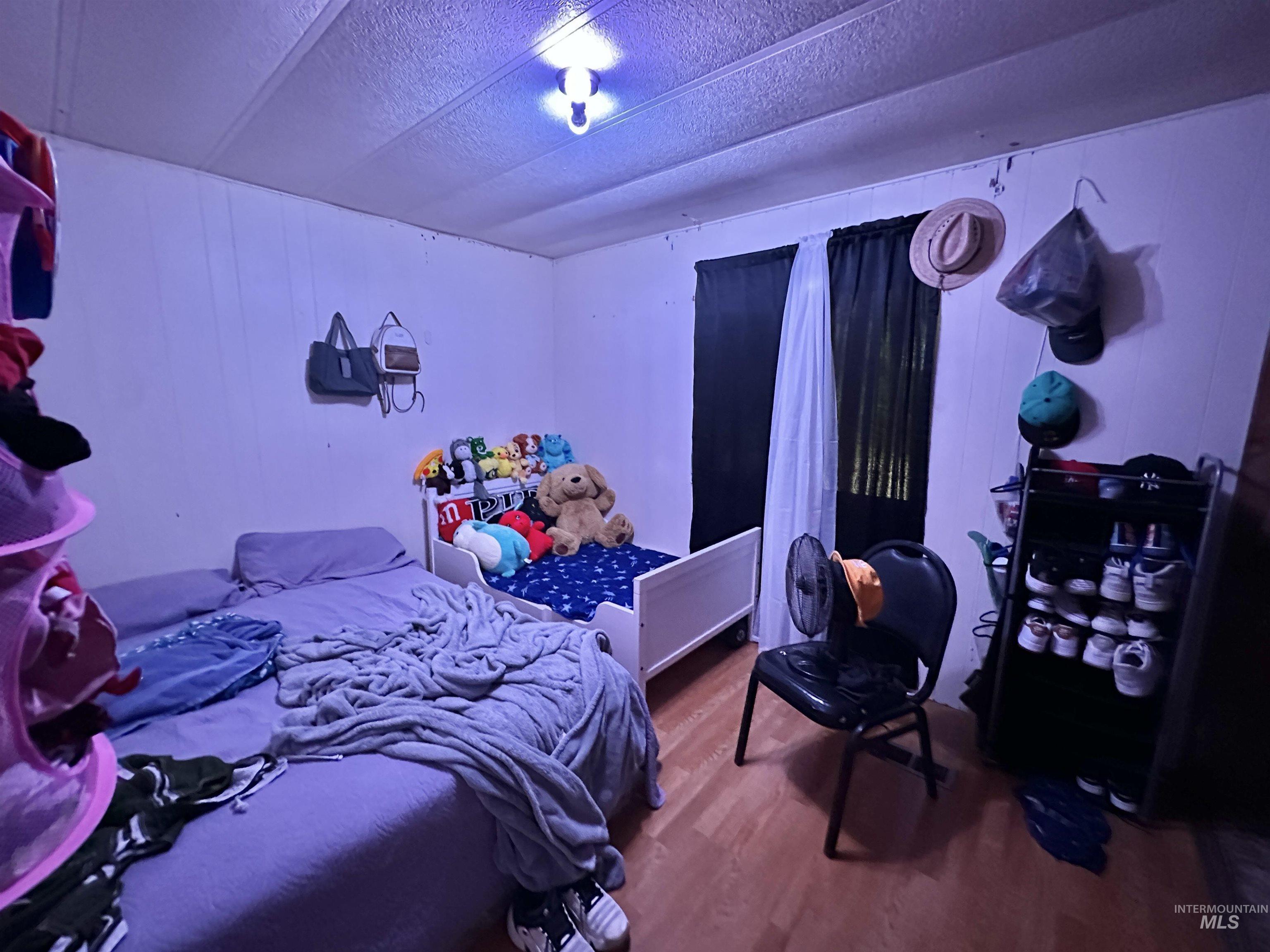 Bedroom featuring dark wood-style flooring and a textured ceiling