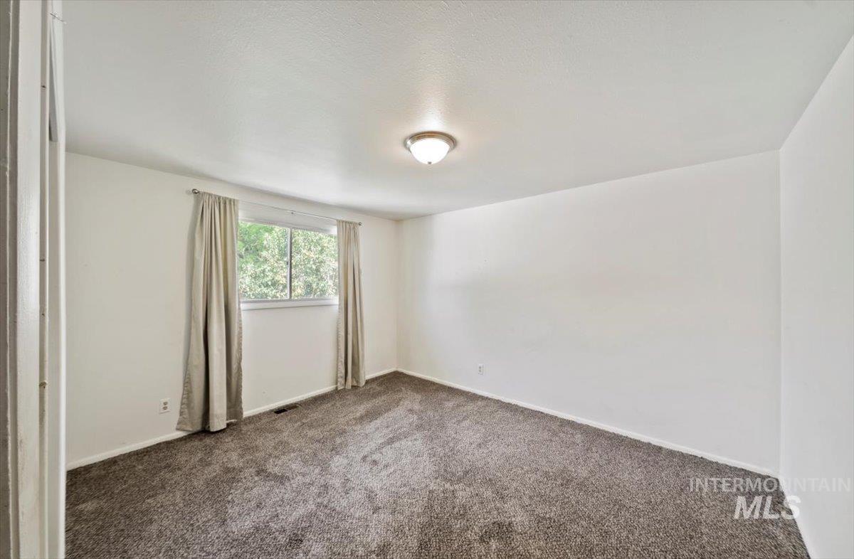 Carpeted empty room with baseboards