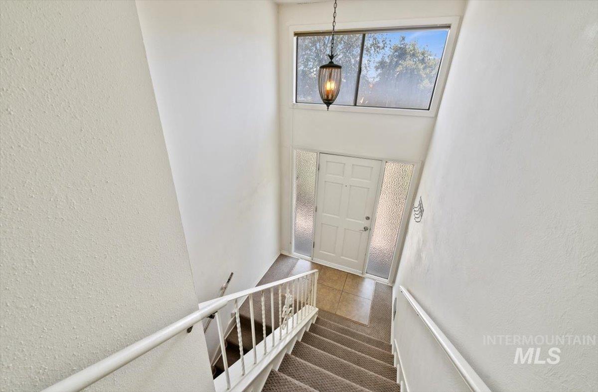 Staircase featuring a textured wall, tile patterned flooring, and carpet flooring