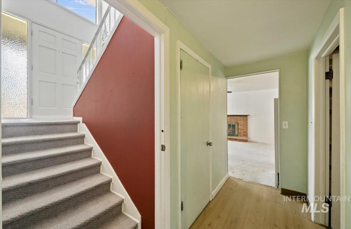 Stairway with wood finished floors and a fireplace