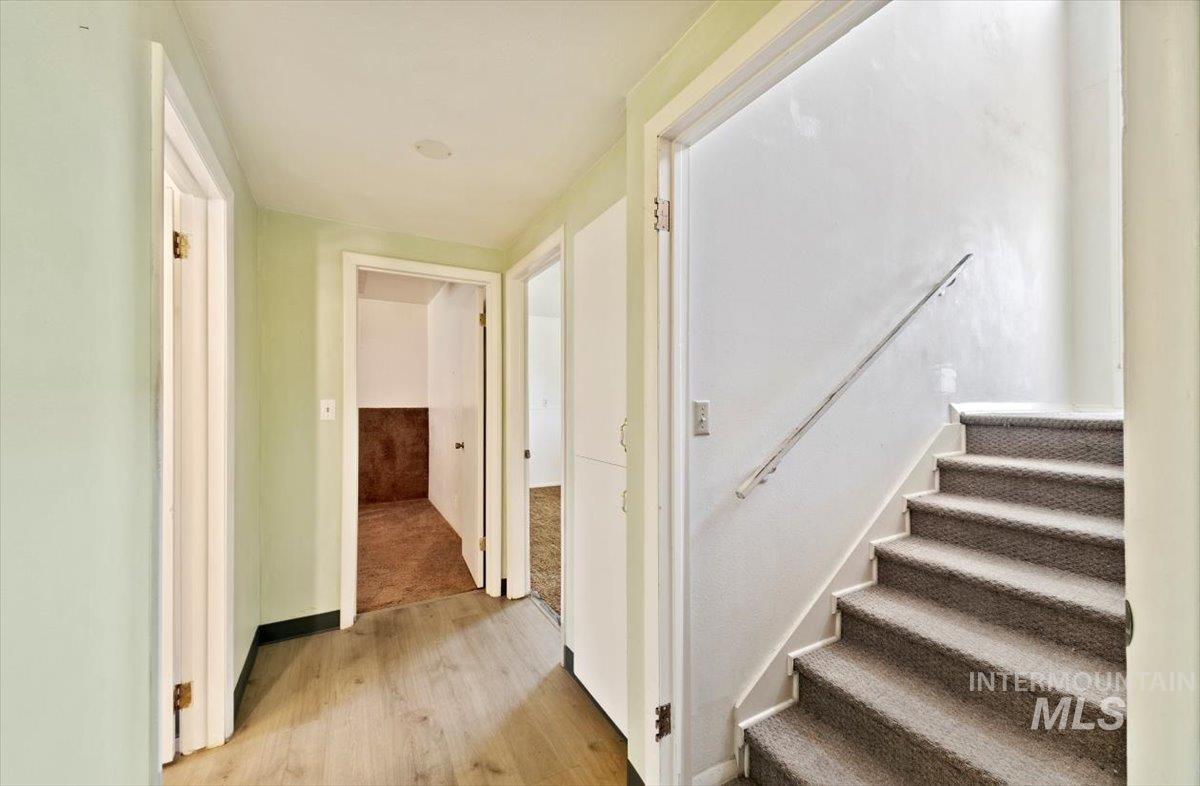 Stairs with wood finished floors and baseboards