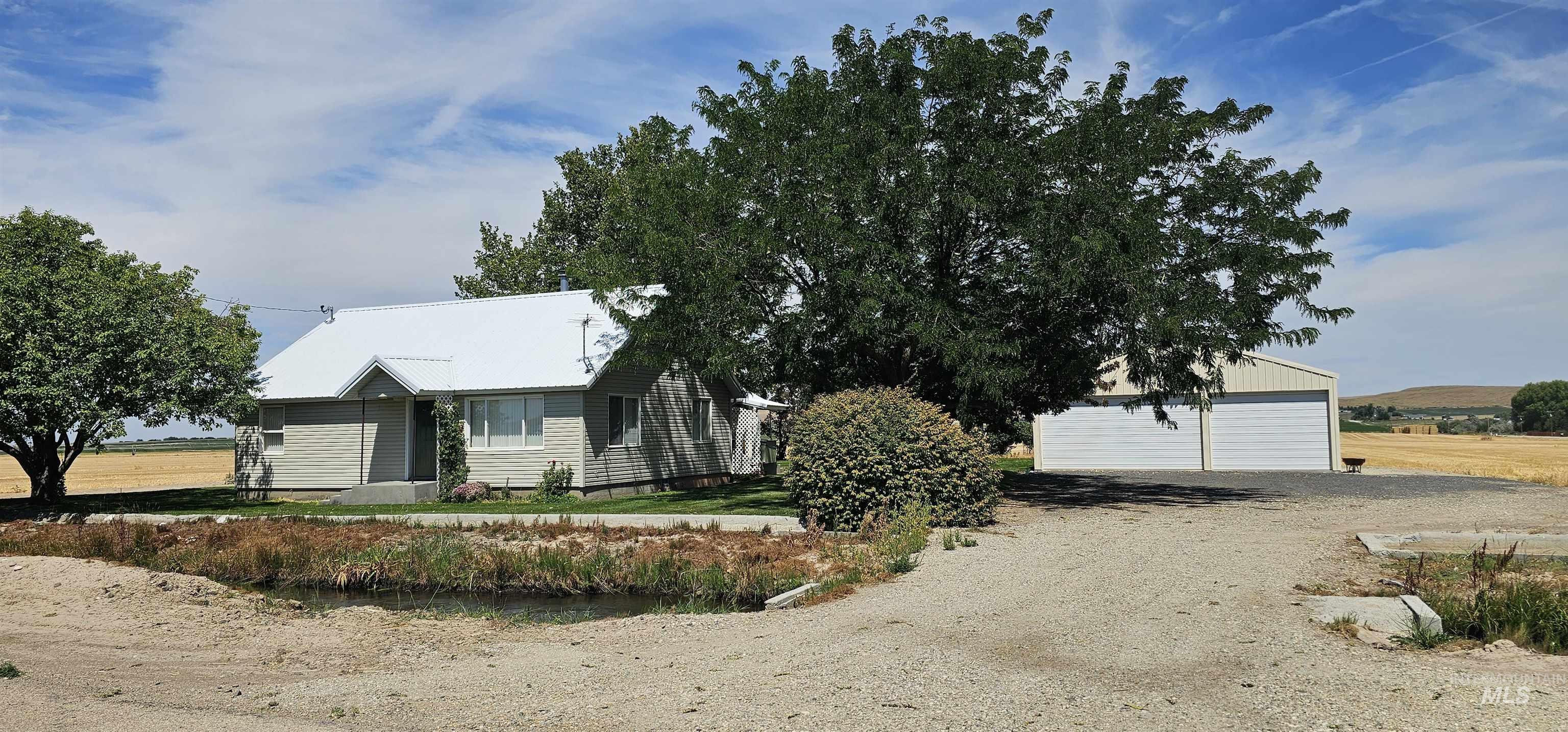 View of front facade featuring an outdoor structure and a detached garage