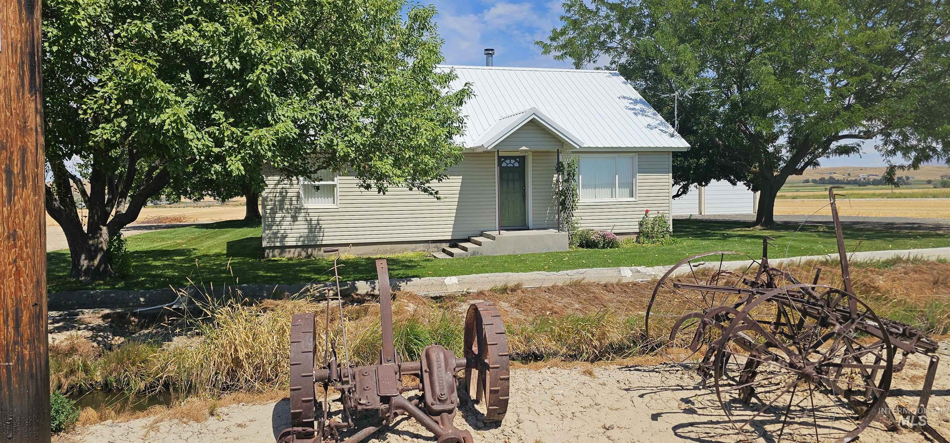 View of front facade featuring a metal roof and a front yard