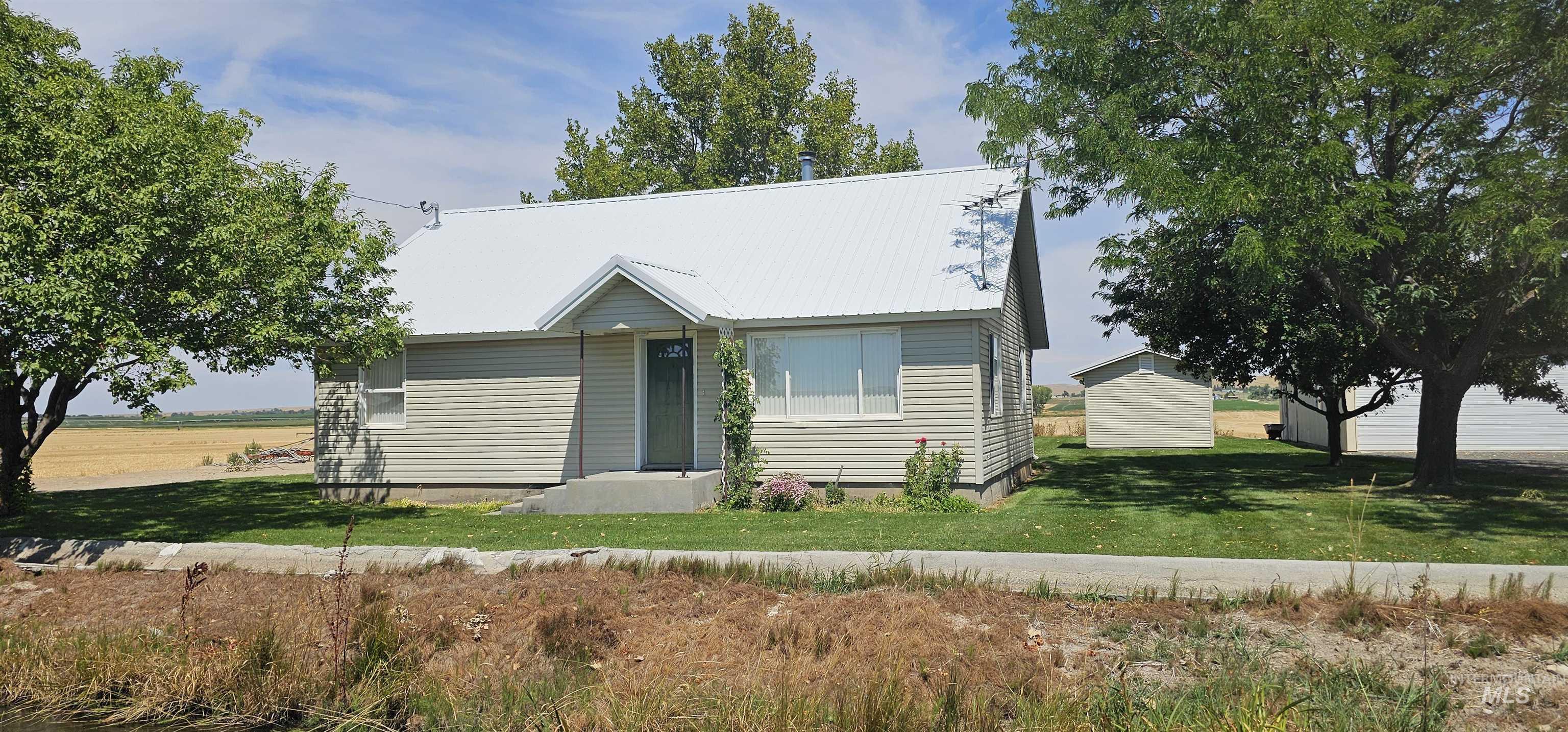 View of front of house featuring a front lawn and a metal roof