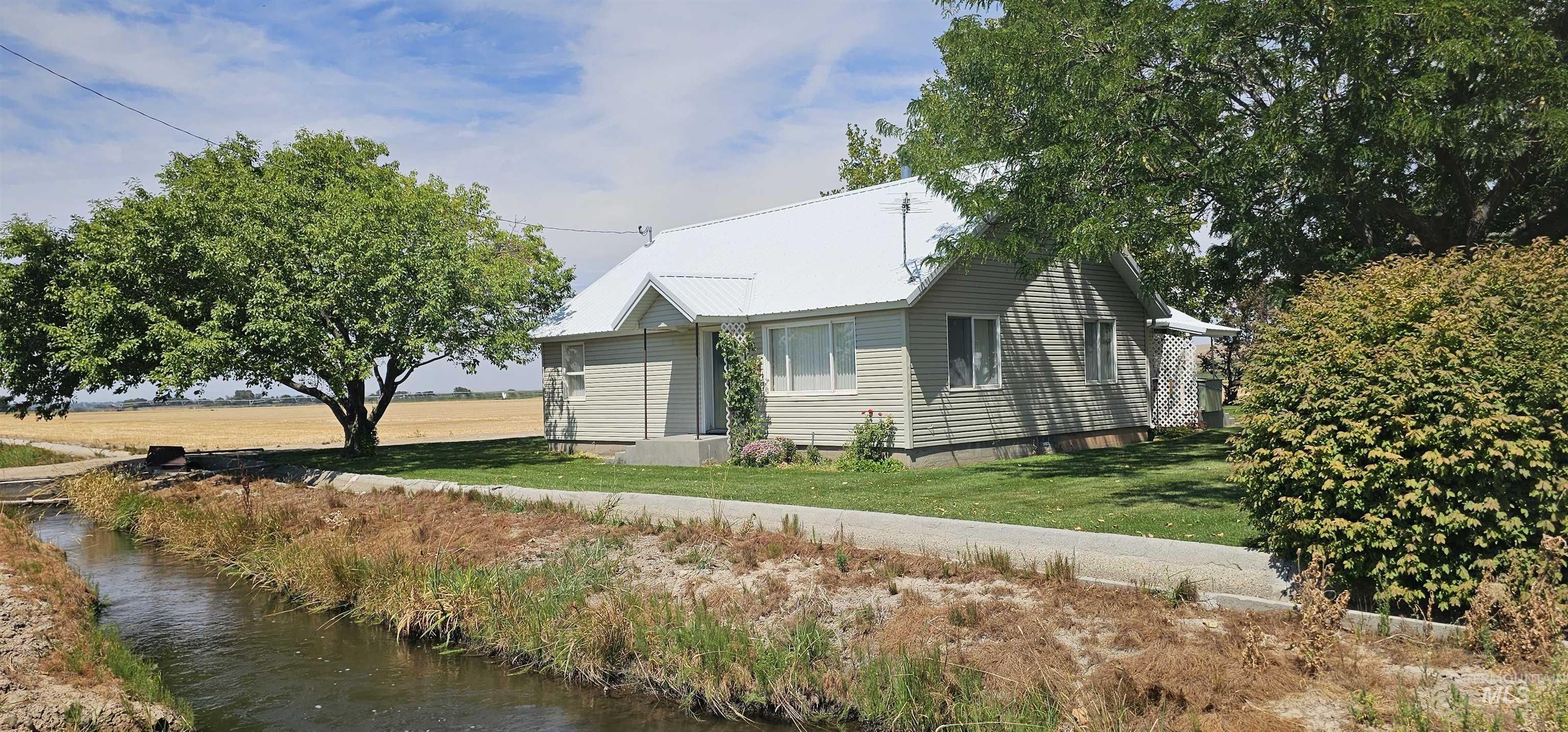 View of front facade featuring a water view and a front lawn