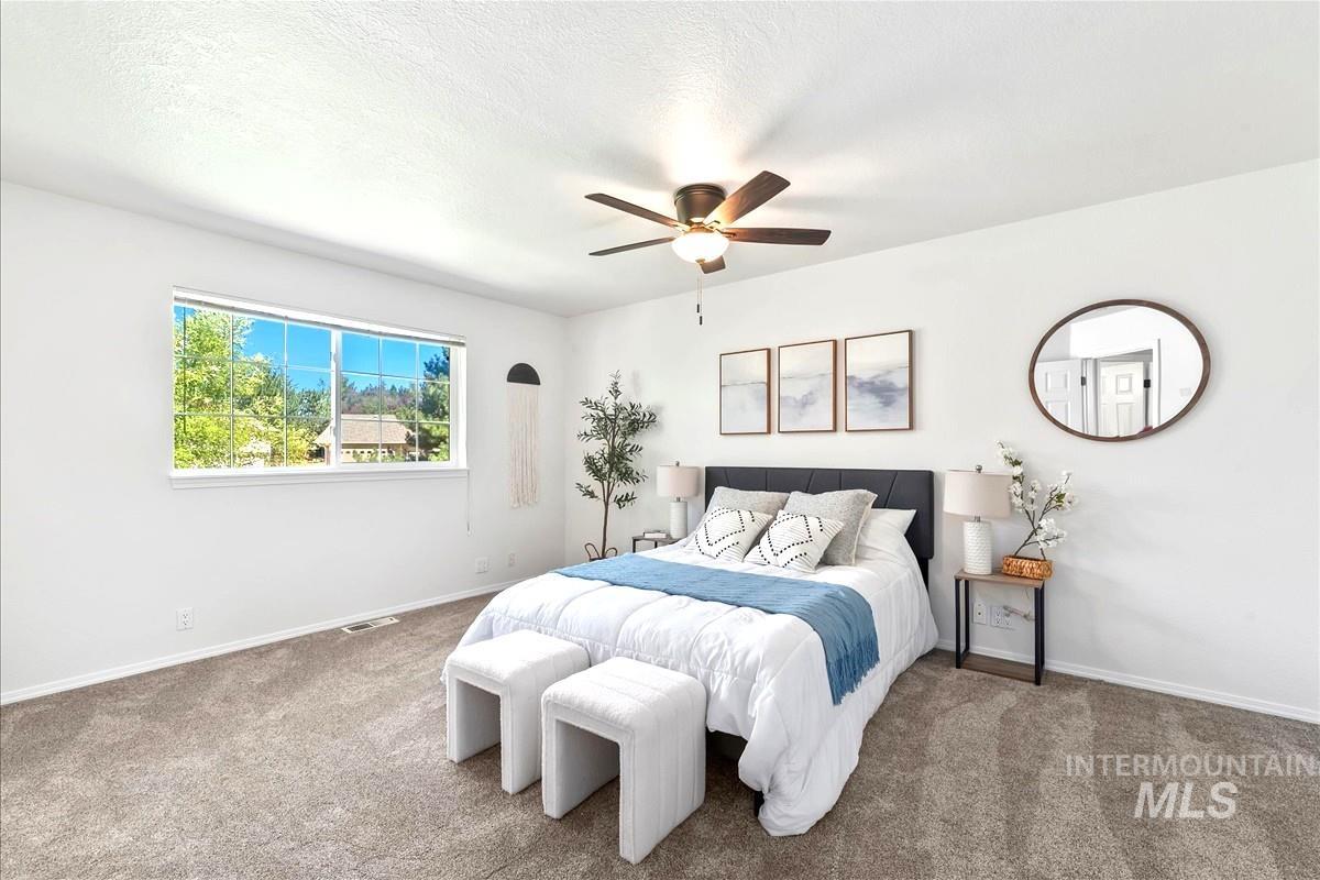 Bedroom featuring carpet, a ceiling fan, and a textured ceiling