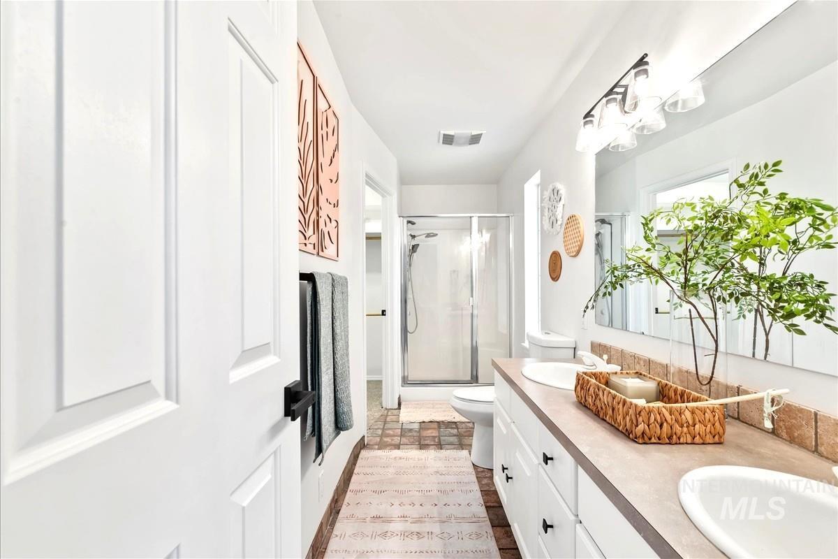 Full bathroom featuring a stall shower and a sink