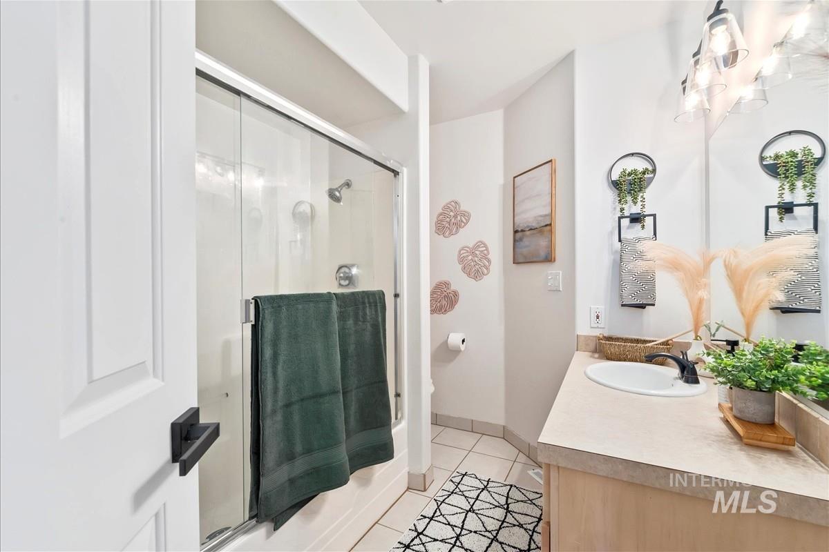 Bathroom with light tile patterned floors and vanity