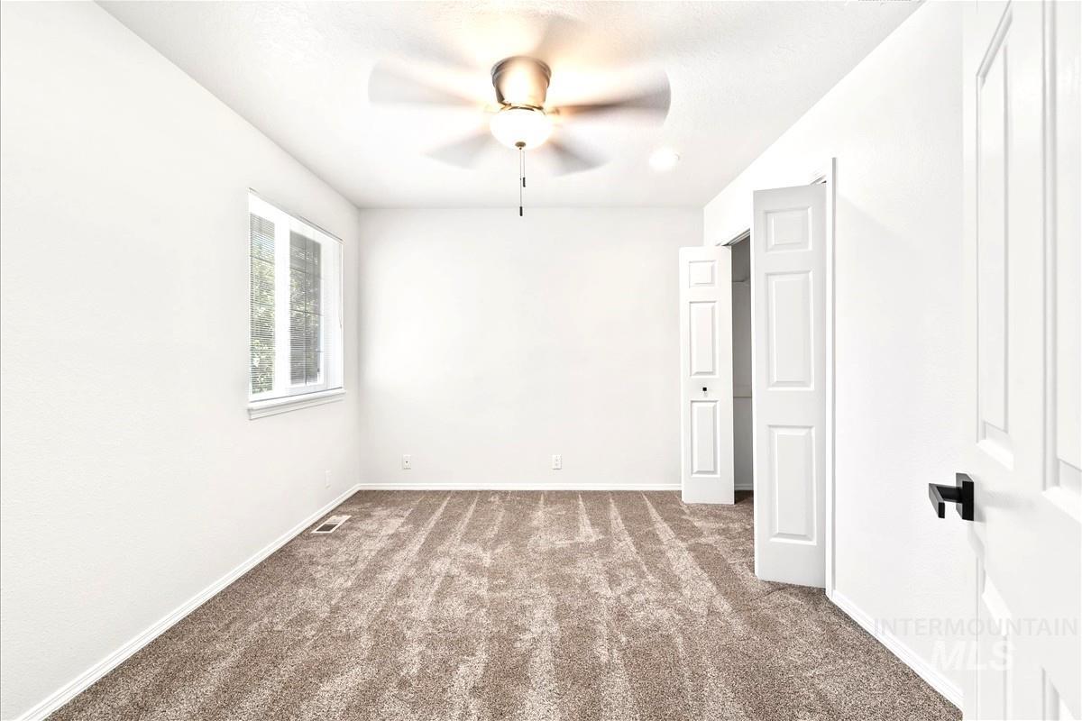 Unfurnished bedroom featuring carpet floors and ceiling fan