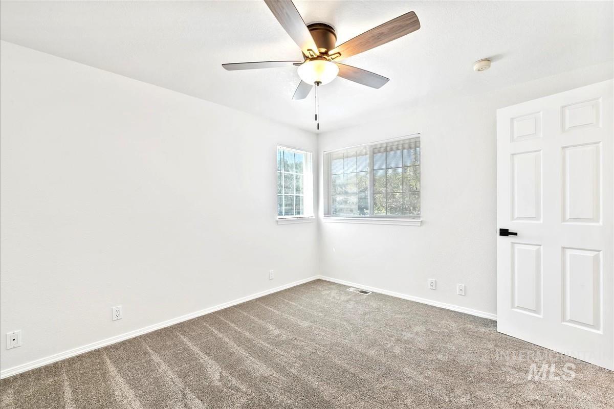 Unfurnished bedroom featuring carpet flooring and ceiling fan
