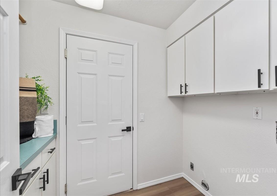 Laundry area featuring cabinet space and light wood-style flooring