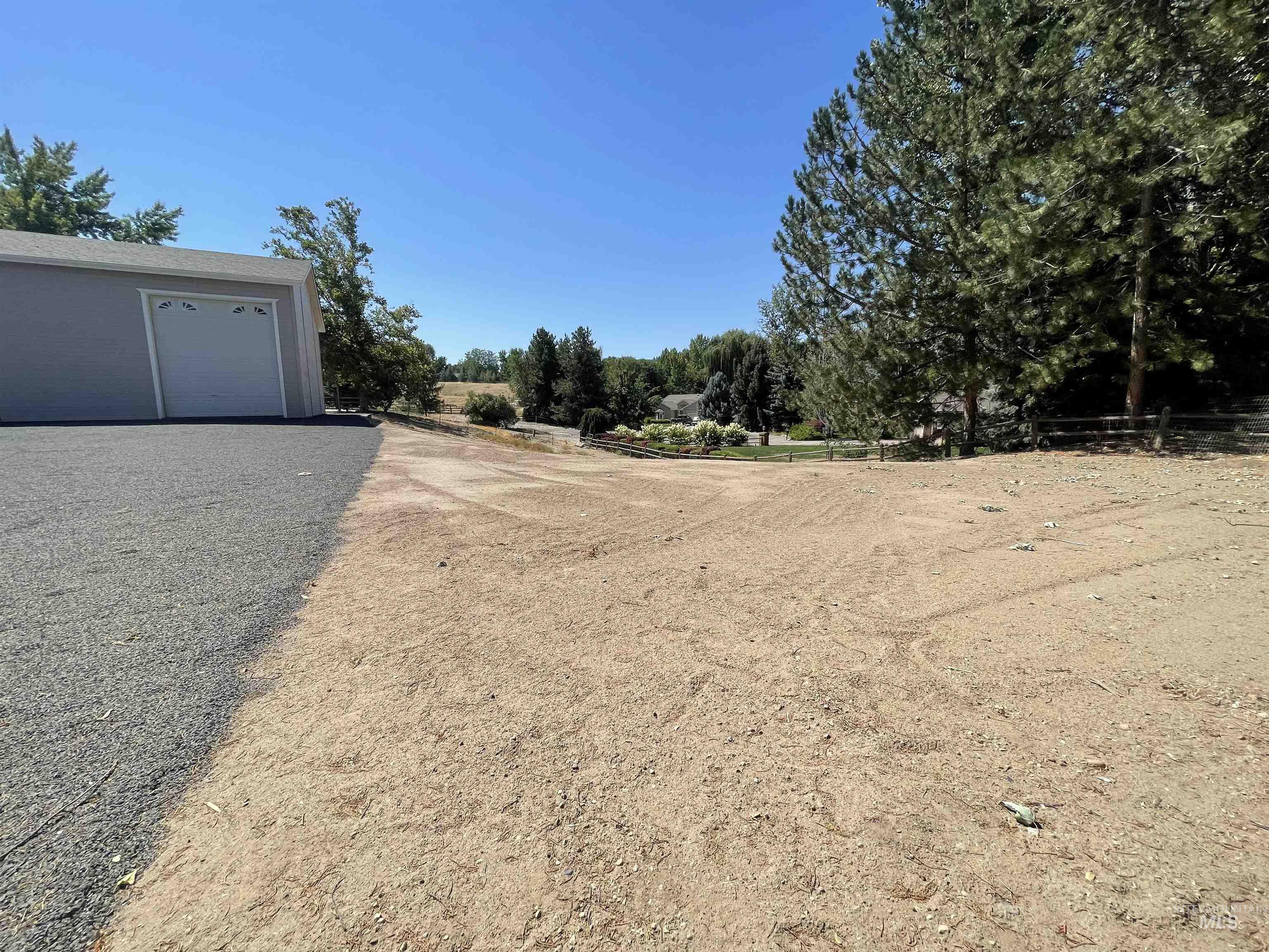 View of yard with a garage and view of wooded area