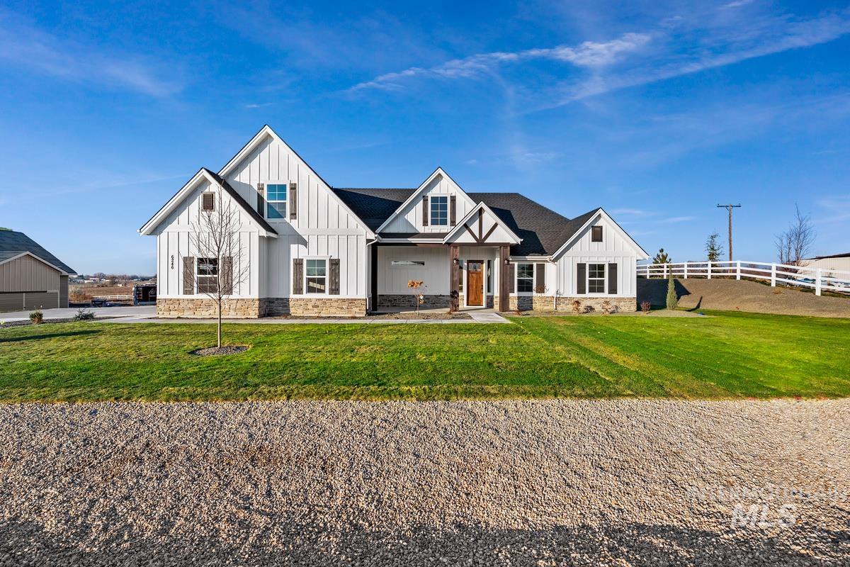 Modern farmhouse style home featuring board and batten siding, covered porch, and stone siding