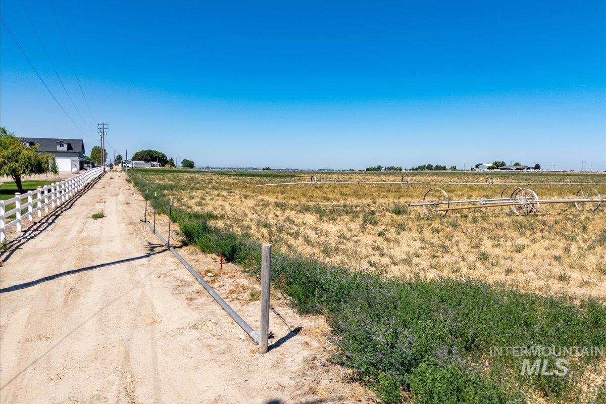 View of dirt / gravel driveway featuring a view of rural / pastoral area